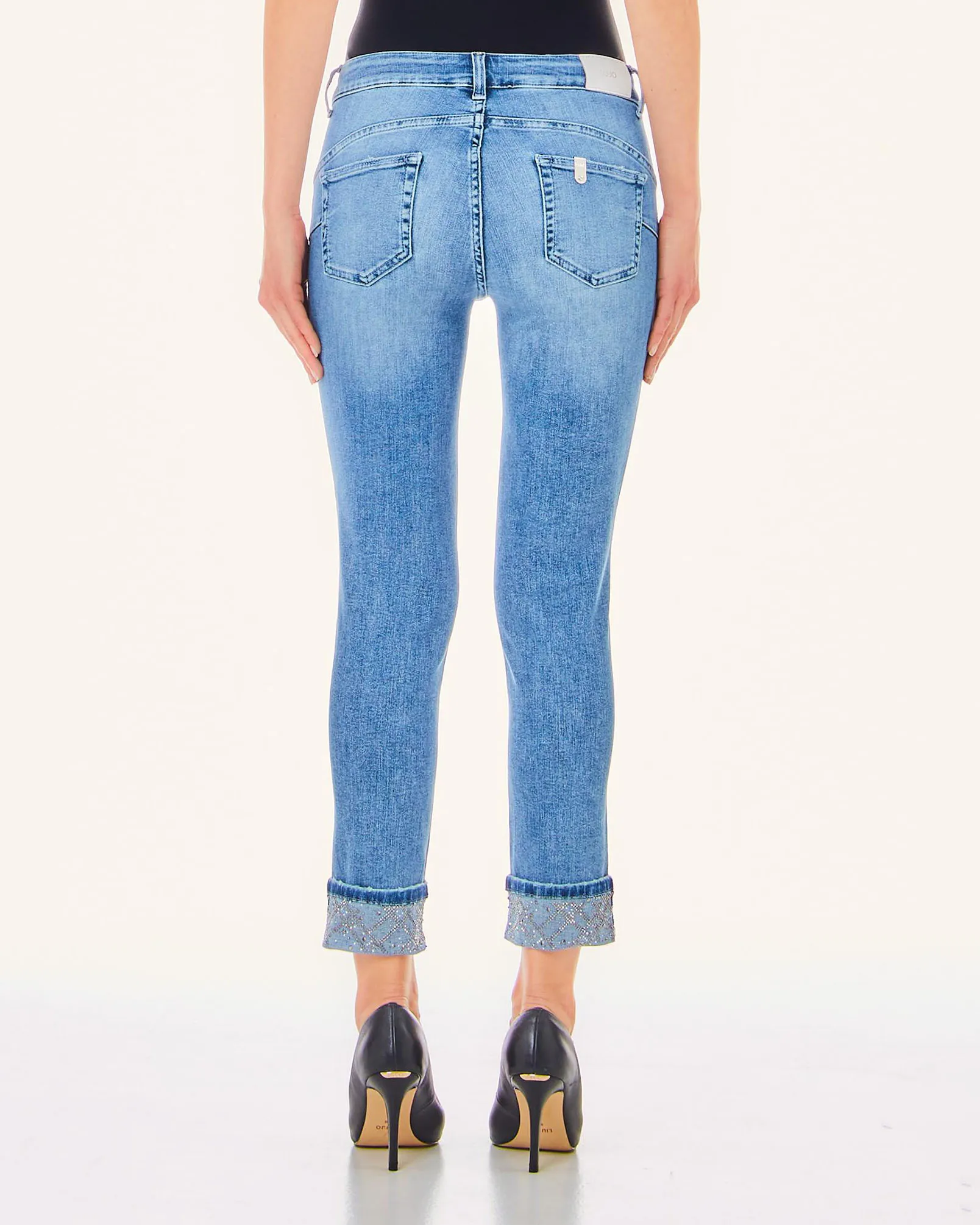 Jeans blu super stone washed in cotone stretch con strass applicati sul risvolto al fondo